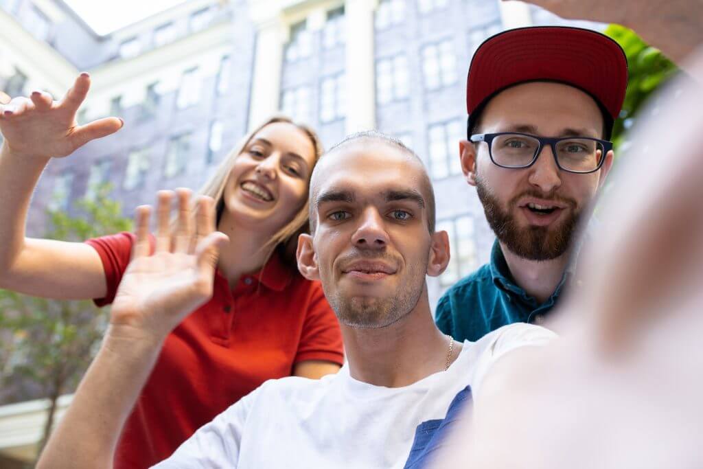 Group of friends taking a stroll on city's street in summer day