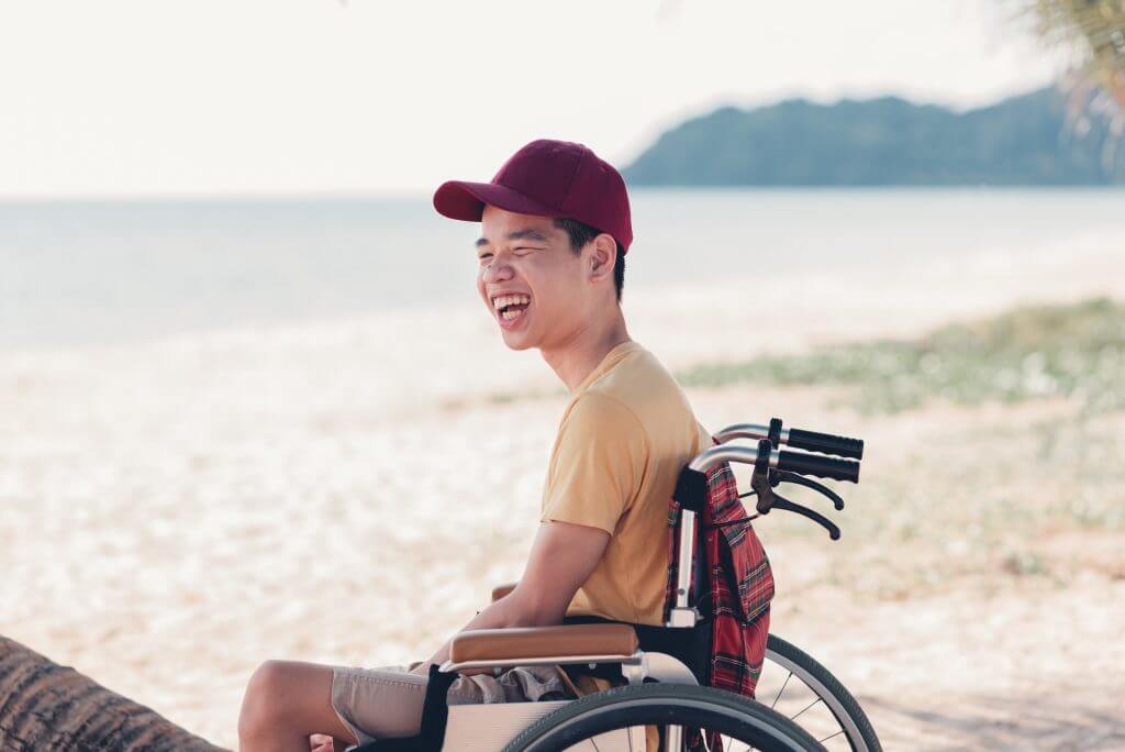 Young man with disability with happy face on the sea beach